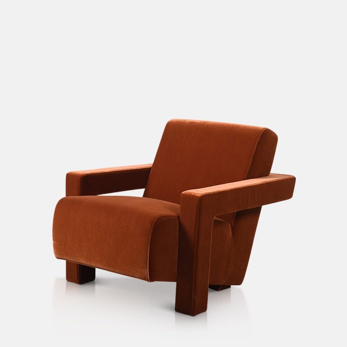 Abigail Ahern Phoenix Velvet Armchair in rich burnt orange velvet, featuring a plush upholstered seat and backrest, angular armrests and a gently reclined modern silhouette.