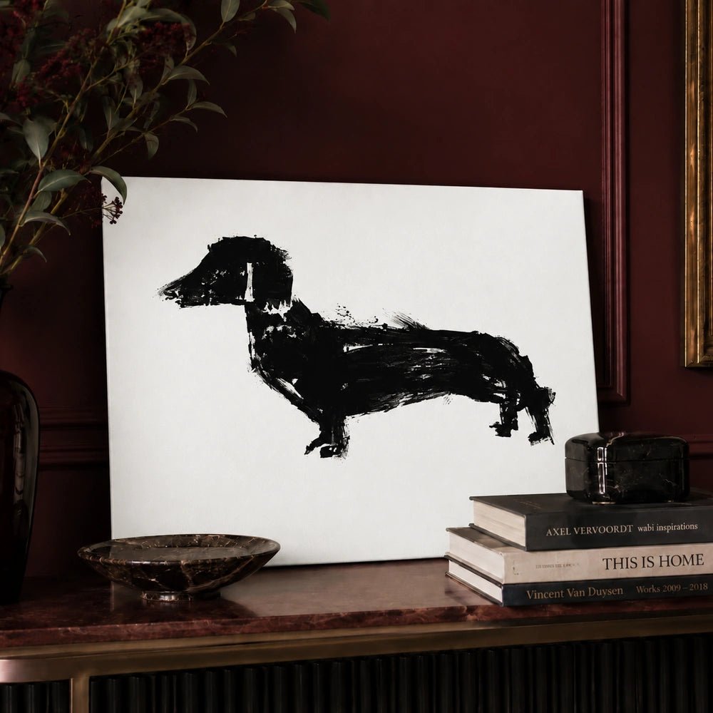 Poppy Dog Print featuring a bold black painted dog silhouette on a white ground, styled on a console against deep burgundy walls with books.