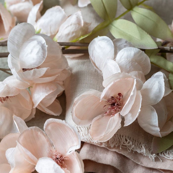Detail of the pale pink fabric petals of the quince blossoms stems.