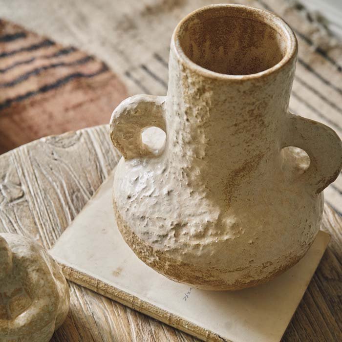 Textured cream ceramic opaque vase in an organic shape. A wide base and a narrower stem with two handles ideal for styling faux flowers
