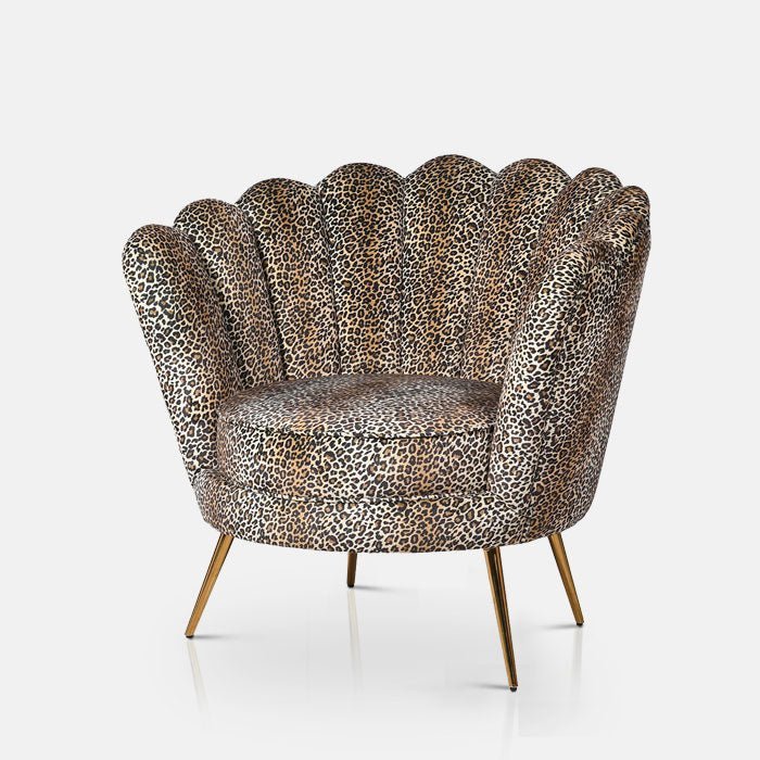 A cutout of the Reno Leopard Print Armchair, a unique shell-shaped boudoir chair in leopard print with slim gold legs.