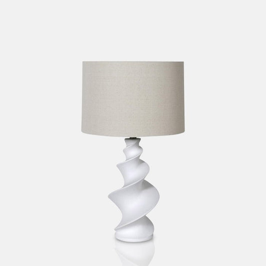 Round cream lampshade sat on a sculptural white spiral base
