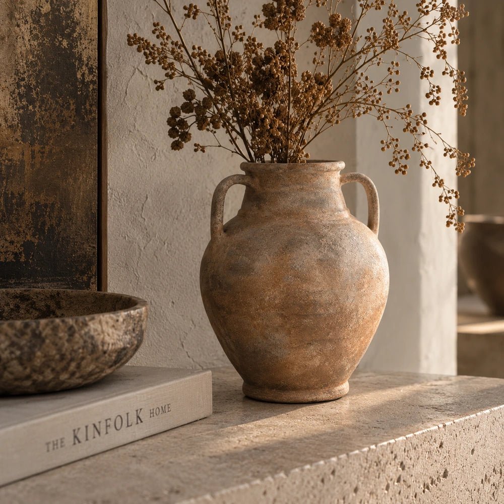 Romeo Vase styled on a console with decorative objects and warm layered textures, creating a contemporary neutral interior vignette around the sculptural vase.