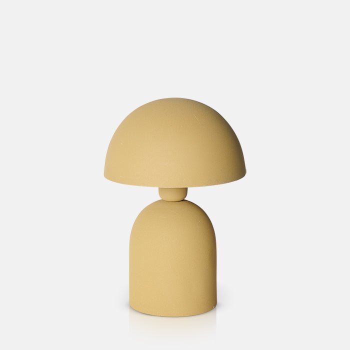 Cutout image on a white background of  a small ochre table lamp with a round base and a matching curved, solid dome shade.