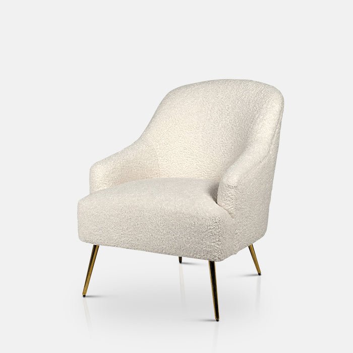 Cream boucle armchair sat on four long golden legs