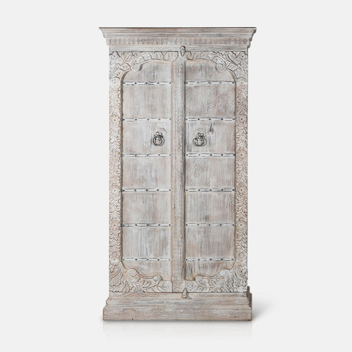 Tall wooden cabinet covered in a white distressed wash and carved details