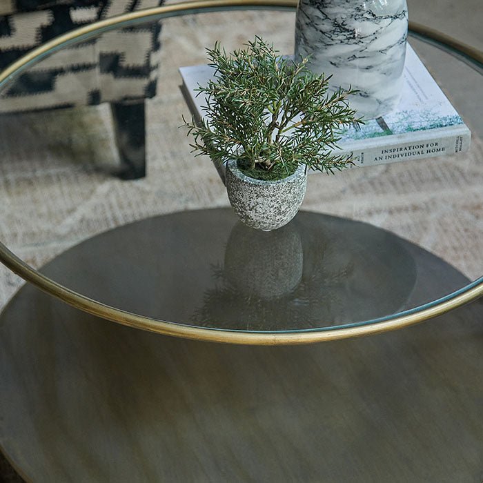 Clear glass round coffee table with gold metal frame.