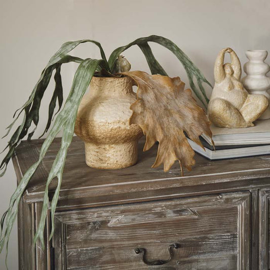 Styled image of our premium fake staghorn fern in a pot on a wooden console.
