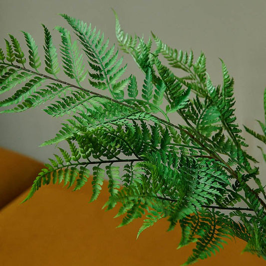 Artificial fern plant with green leaves.