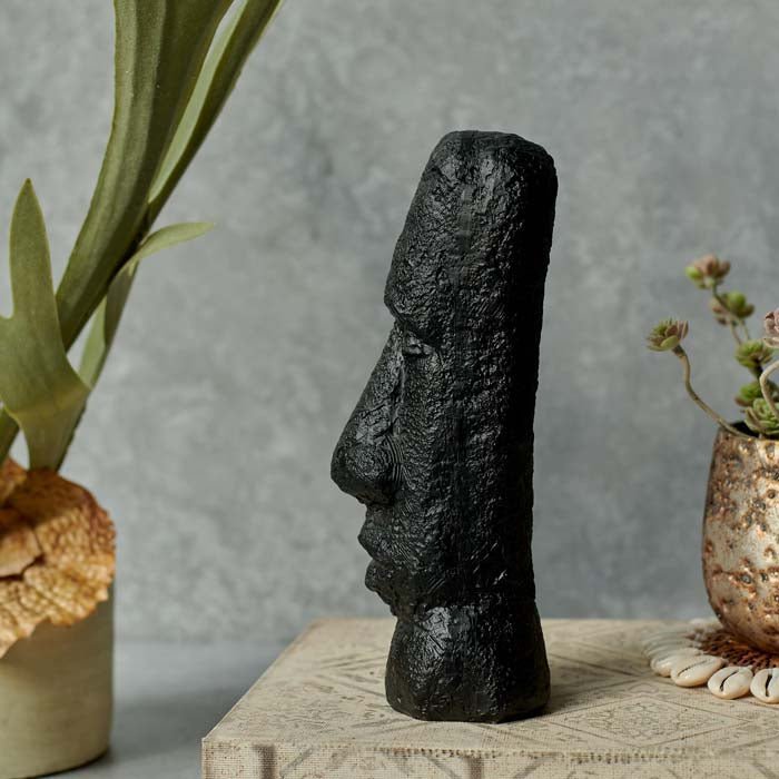 Long face sculpture in black facing to the side