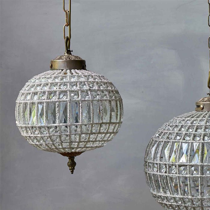 A round chandelier with clear glass crystals and bronzed metal detailing.