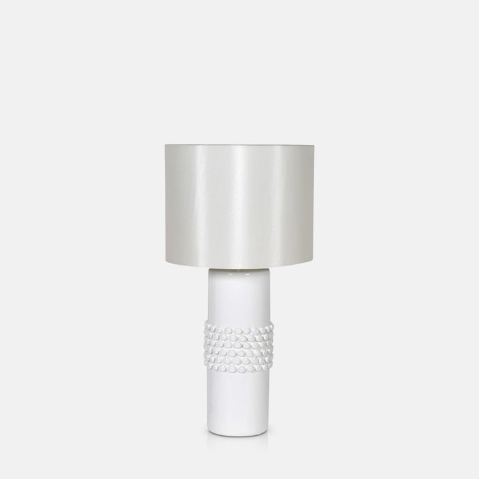 A cutout of the Tavira Bobble Table Lamp. A smooth and bobbled white glazed ceramic base and a linen shade table lamp.