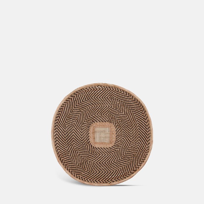A cutout of the Toledo Basket, a circular wide shallow woven basket with a geometric tribal pattern.