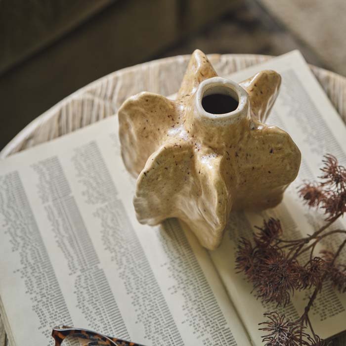 A small ceramic bud vase with an organic shape.