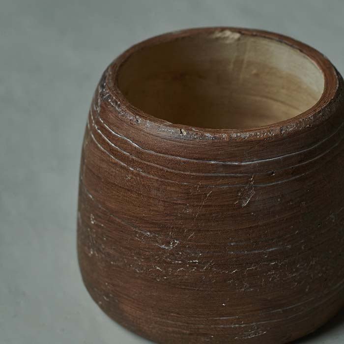 Round brown vase with textured markings and a natural inside finish