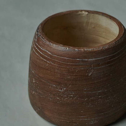 Round brown vase with textured markings and a natural inside finish