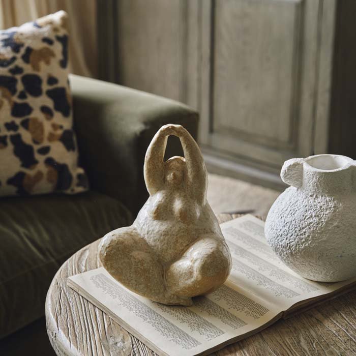 A seated yoga lady female sculpture. Yoga pose sculpture in a cream glazed ceramic to add an arty vibe to your home decor. 