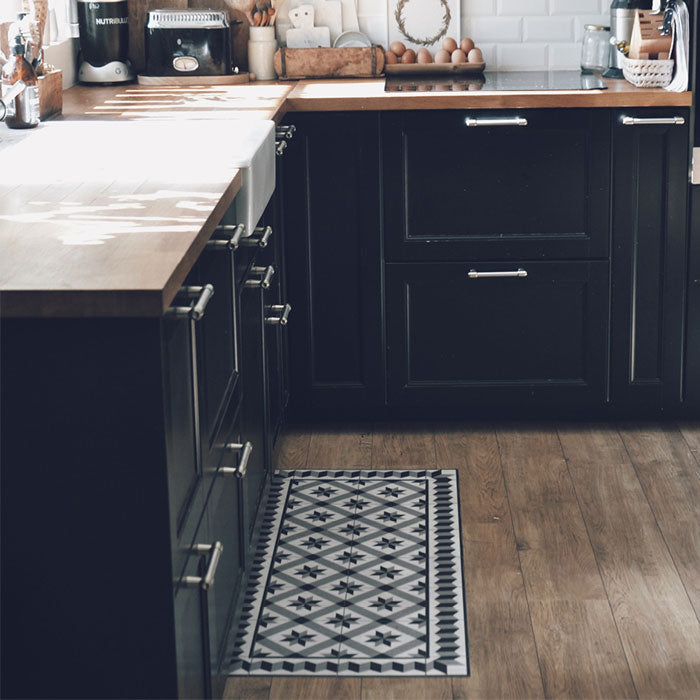 Long black and white vinyl runner on wooden floorboards in a kitchen