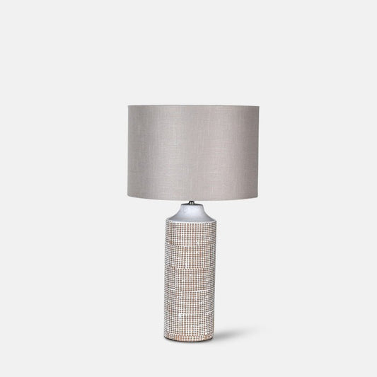 Large table lamp with textured ceramic base and cream drum shade.