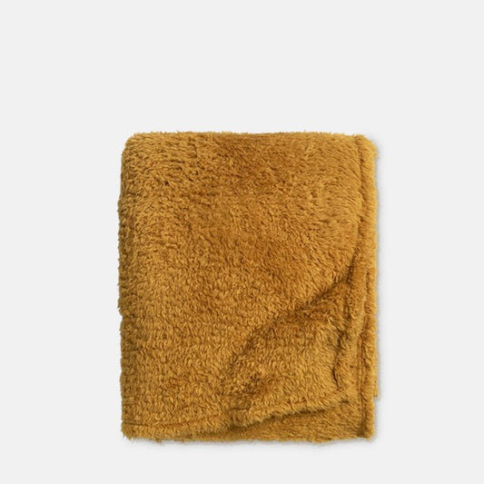 A cutout of a folded super soft faux fur throw in golden yellow. Abigail Ahern, in homes since 2003. Buy now, pay later with Klarna.