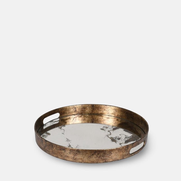 The Wilton Tray, a round tray with an antique glass mirrored surface and burnished antique gold effect handles.