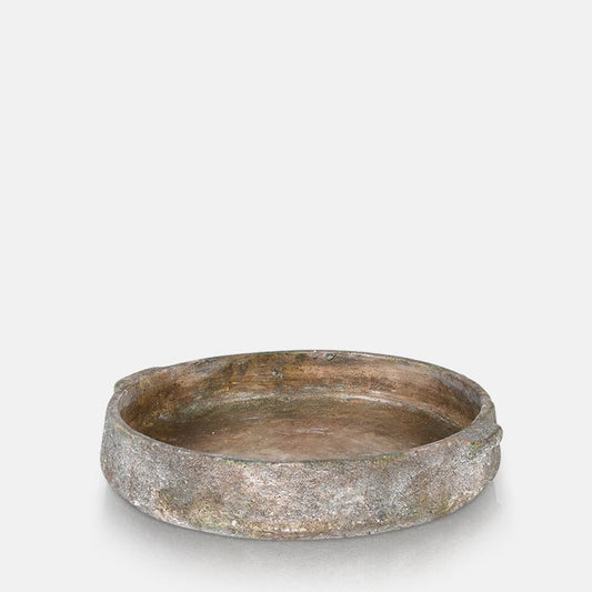 A cutout of a large round textured grey bowl with two handles on either side. A wide bowl with low sides that will look good styled on your dining table or kitchen island.