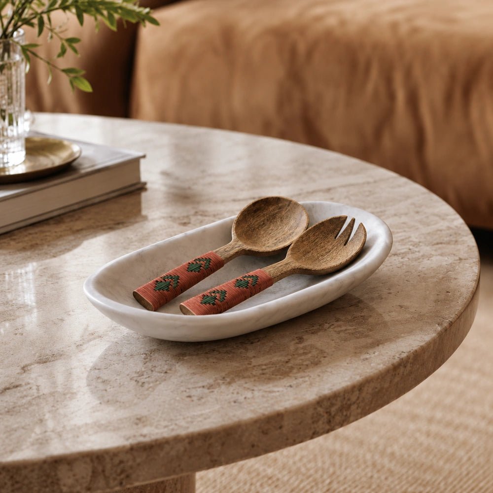 Alba Wooden Salad Servers with carved wooden spoon and fork, wrapped coral and green handles, displayed in a white serving dish on a stone table.