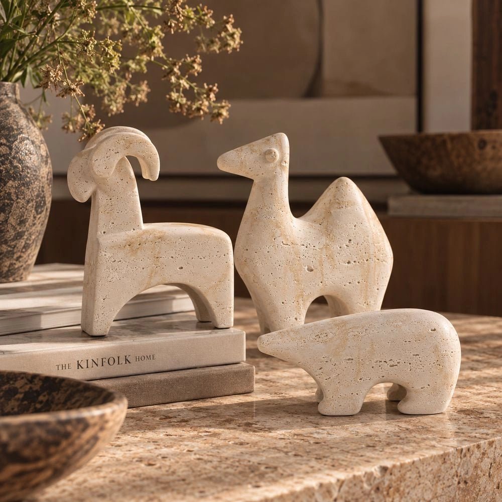 Animal Sculptures set of three pale abstract animal figures arranged together, showing their rounded textured forms and contrasting horned and elongated silhouettes.