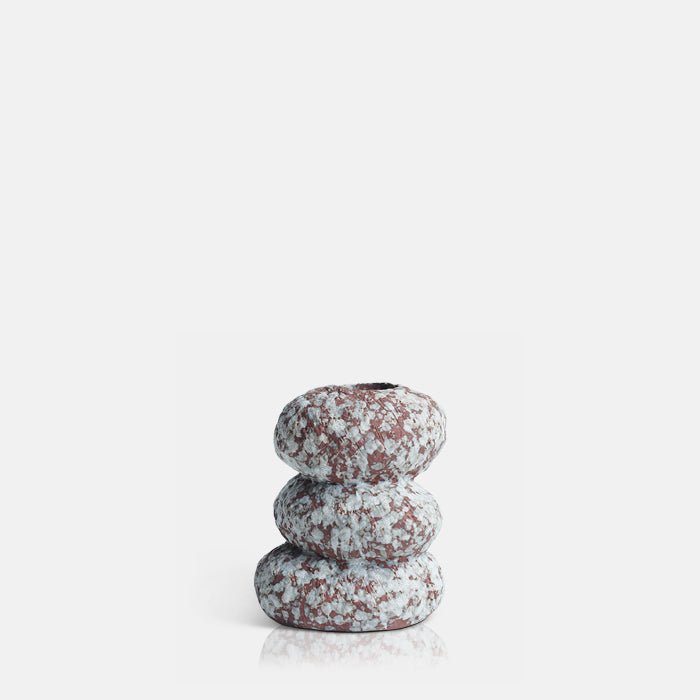 Cutout image on a white background of a small brown vase with a speckled white glaze. The vase has three round segments and an organic look.