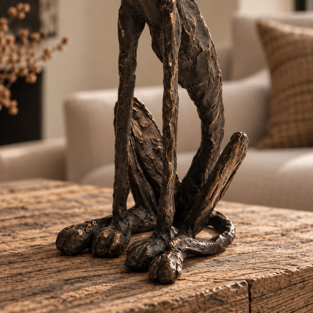 Arnie Sculpture displayed on a round coffee table, its dark angular dog form surrounded by neutral seating, books and textured decorative objects.