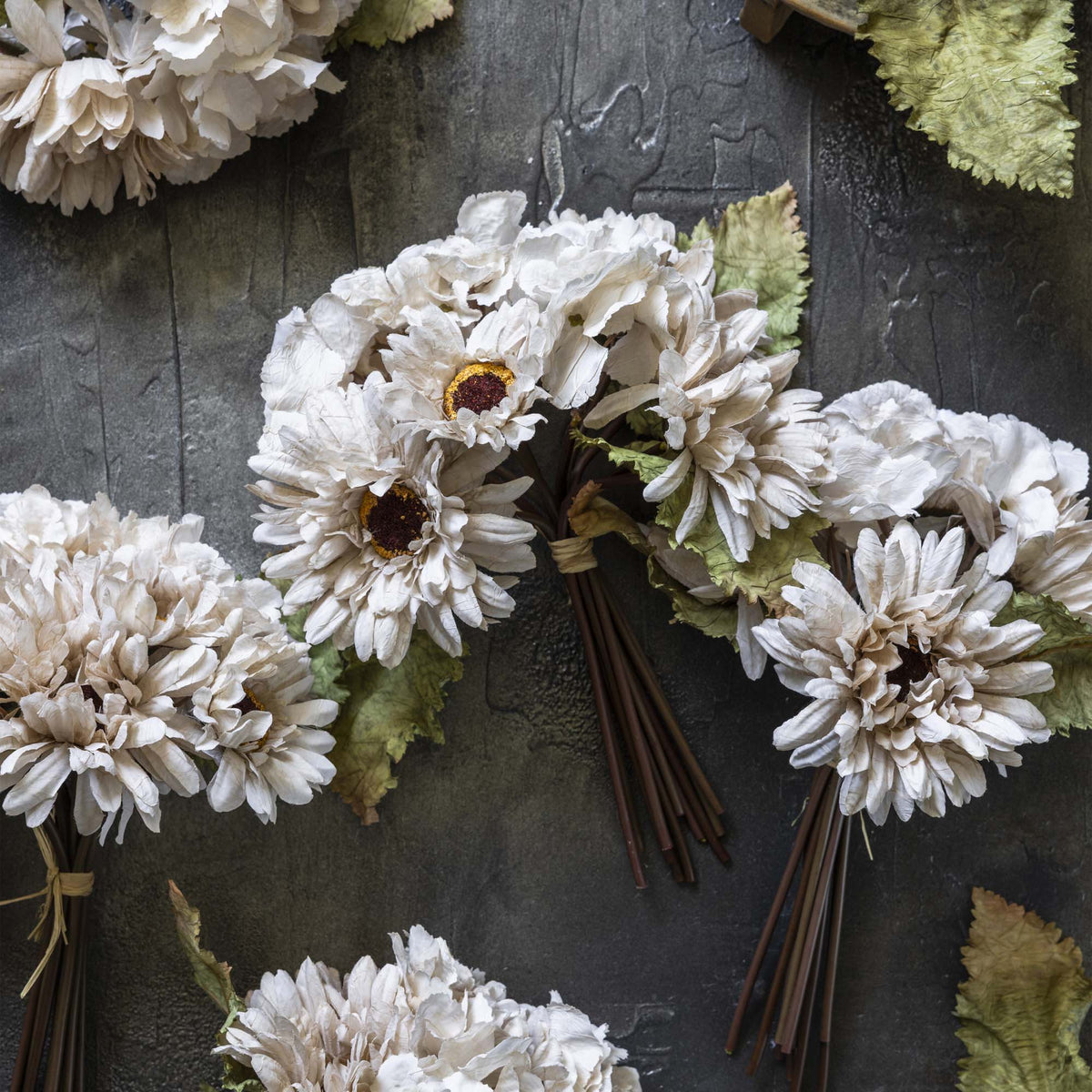 White artificial flowers on a textured dark surface