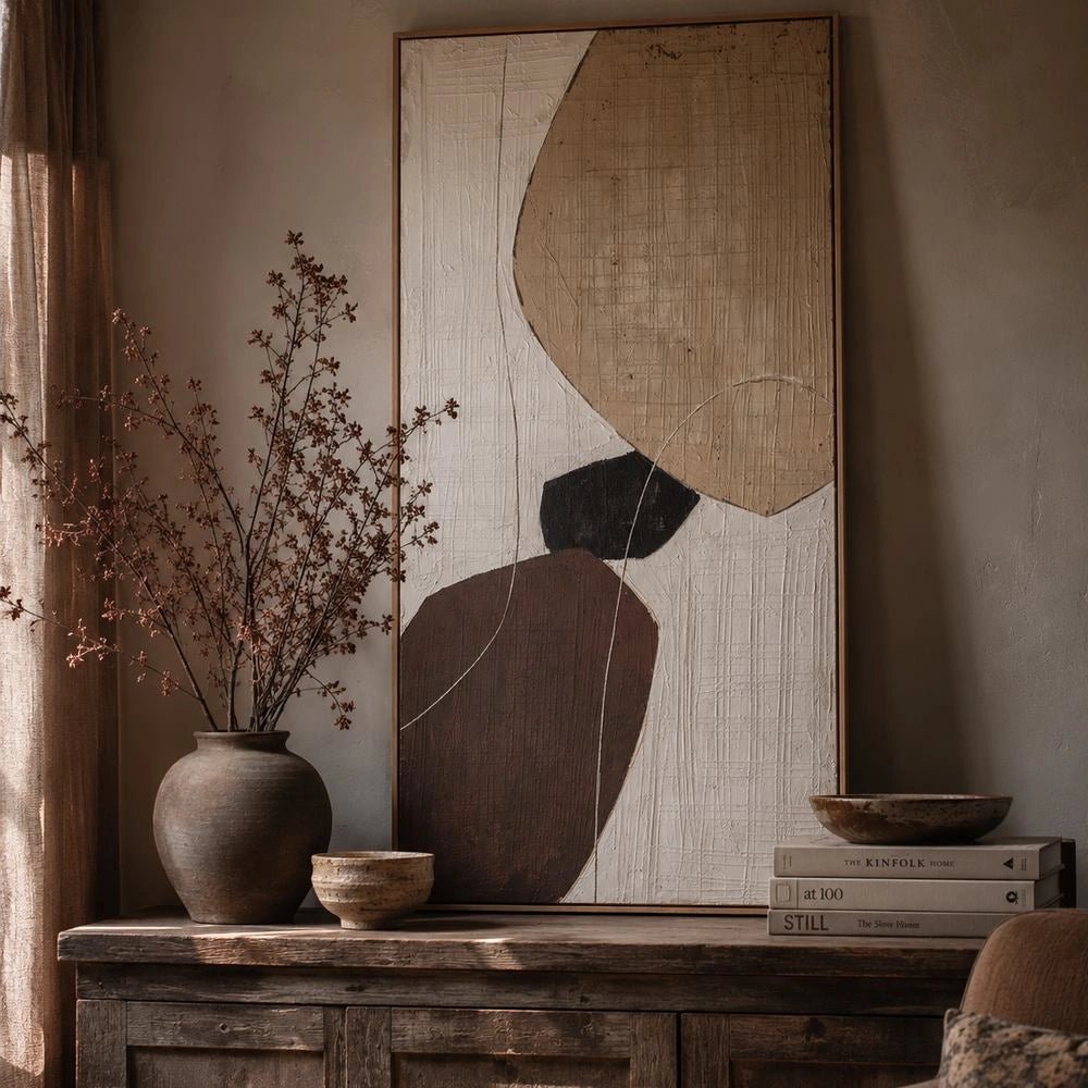Balance Painting with abstract neutral geometric forms displayed above a rustic console, styled with a rounded vase, dried branches, stacked books and warm earthy decor.