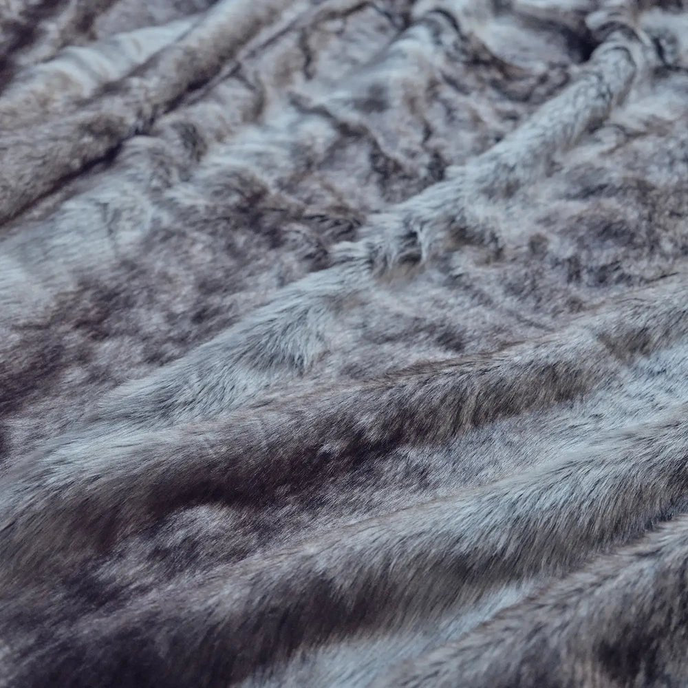 Calvert Faux Fur Throw showing dense grey fur with softly rippled folds and varied tonal shading, photographed closely to highlight its plush surface texture.