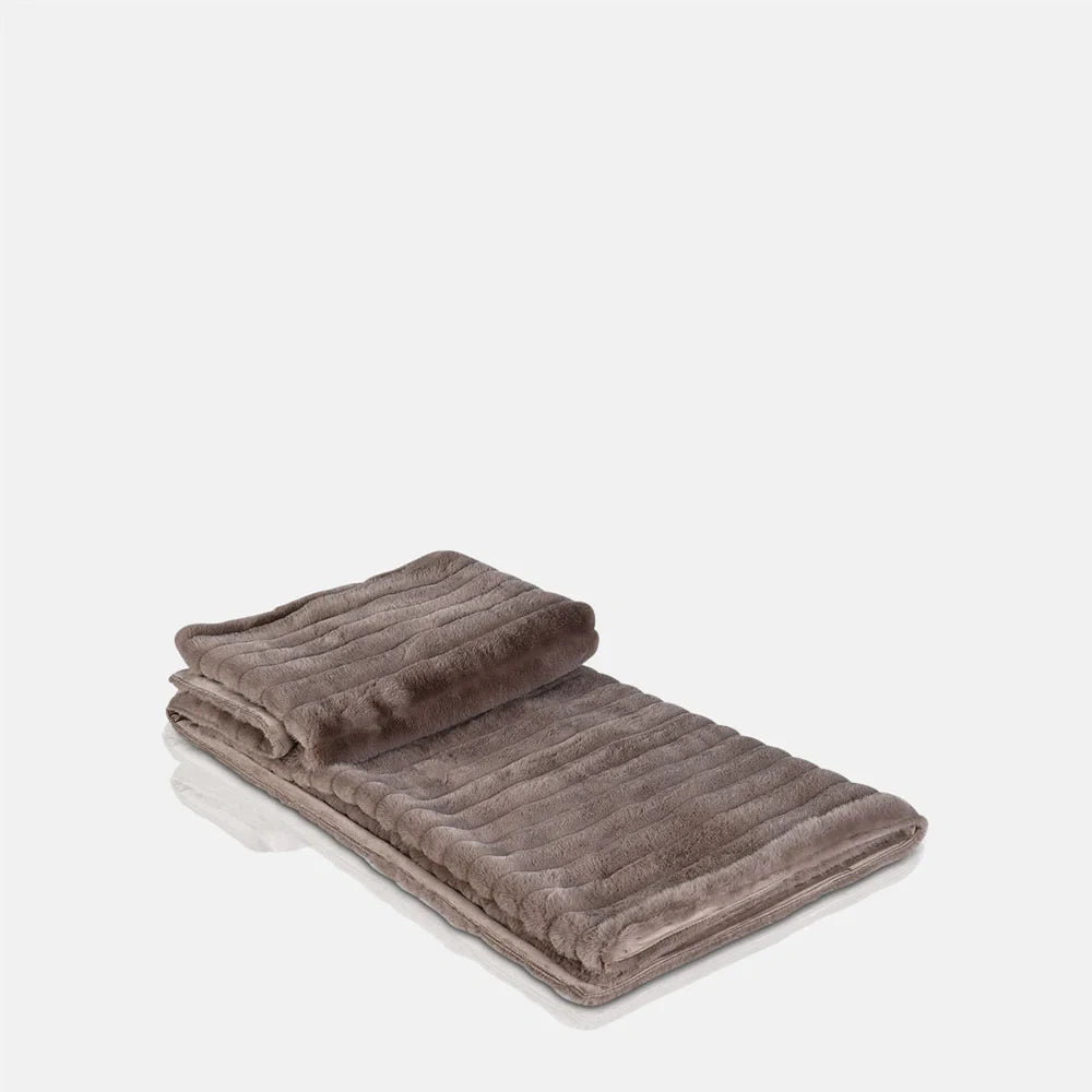 Chandler faux fur throw folded to show its muted taupe colour, broad ribbed texture, fluffy pile and contrasting smooth backing along the turned edge.