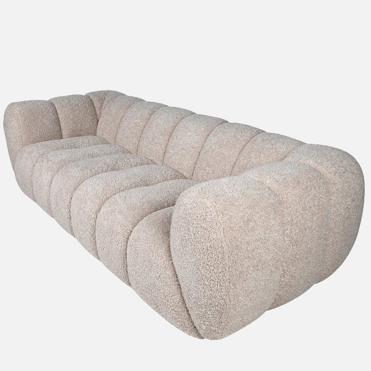 Luxury beige 3 seater sofa with a plush upholstered finish and sculptural modern silhouette. Cheverell 3-Seater Sofa by Abigail Ahern, designed with a soft neutral fabric and generous proportions for ultimate comfort and relaxed living. A statement contemporary sofa perfect for modern living rooms, luxury interiors and cosy lounge spaces, adding timeless elegance, texture and sophisticated style to your home decor.