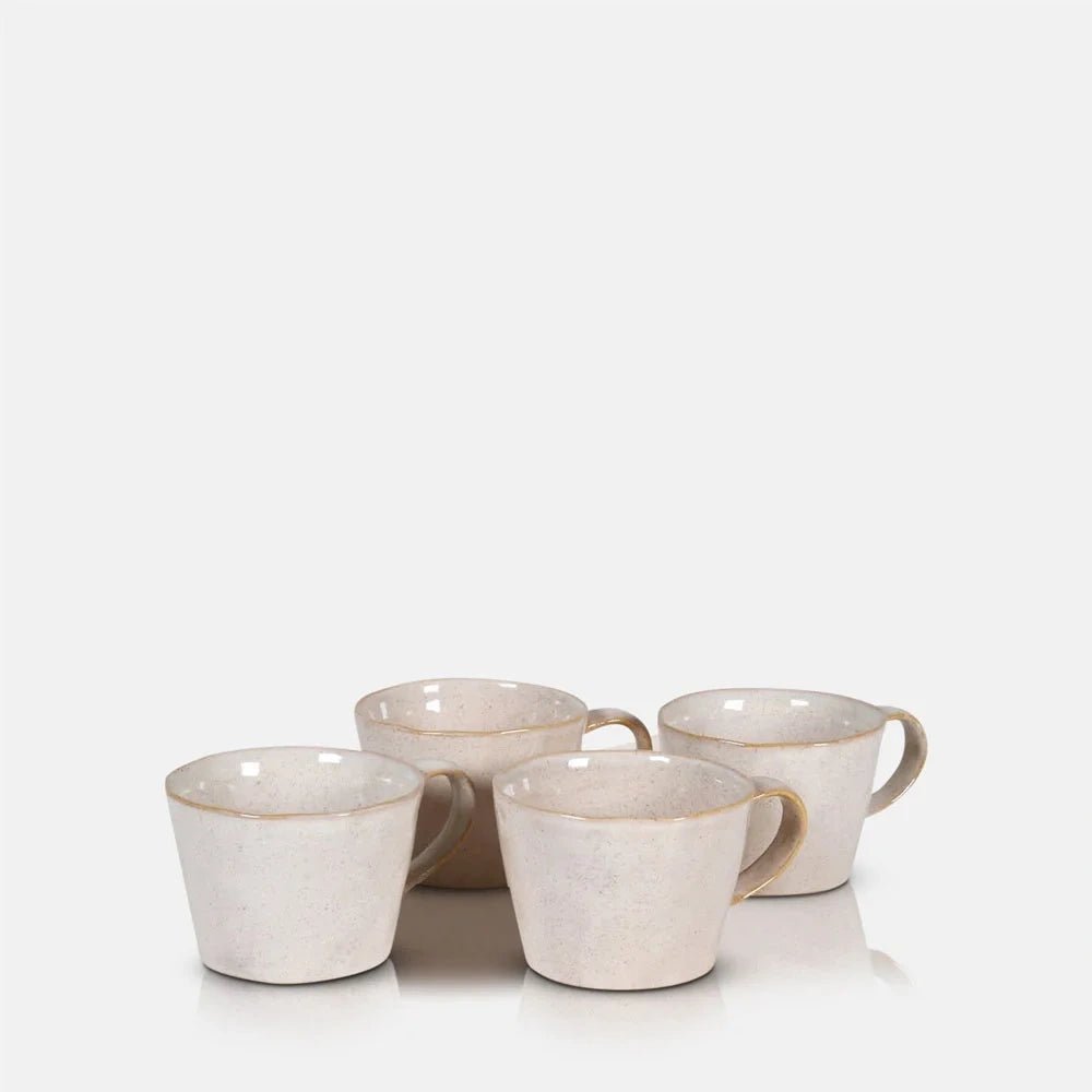 Coleman ceramic mugs grouped together, showing four gently tapered cream cups with rounded handles, softly speckled surfaces and warm neutral tones in their glaze.