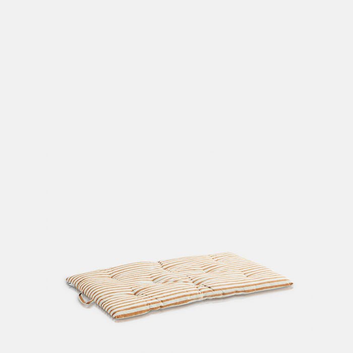 A cutout of the Daltona Mattress, a slim rectangular mattress in warm ochre and sand coloured stripes.