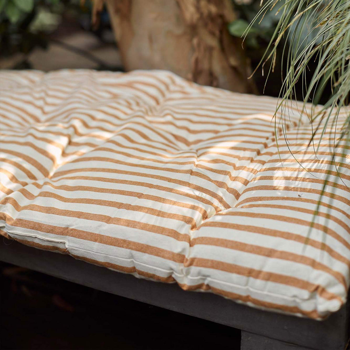 A closeup of the ochre and sand coloured stripe detail on the rectangular Daltona Mattress.