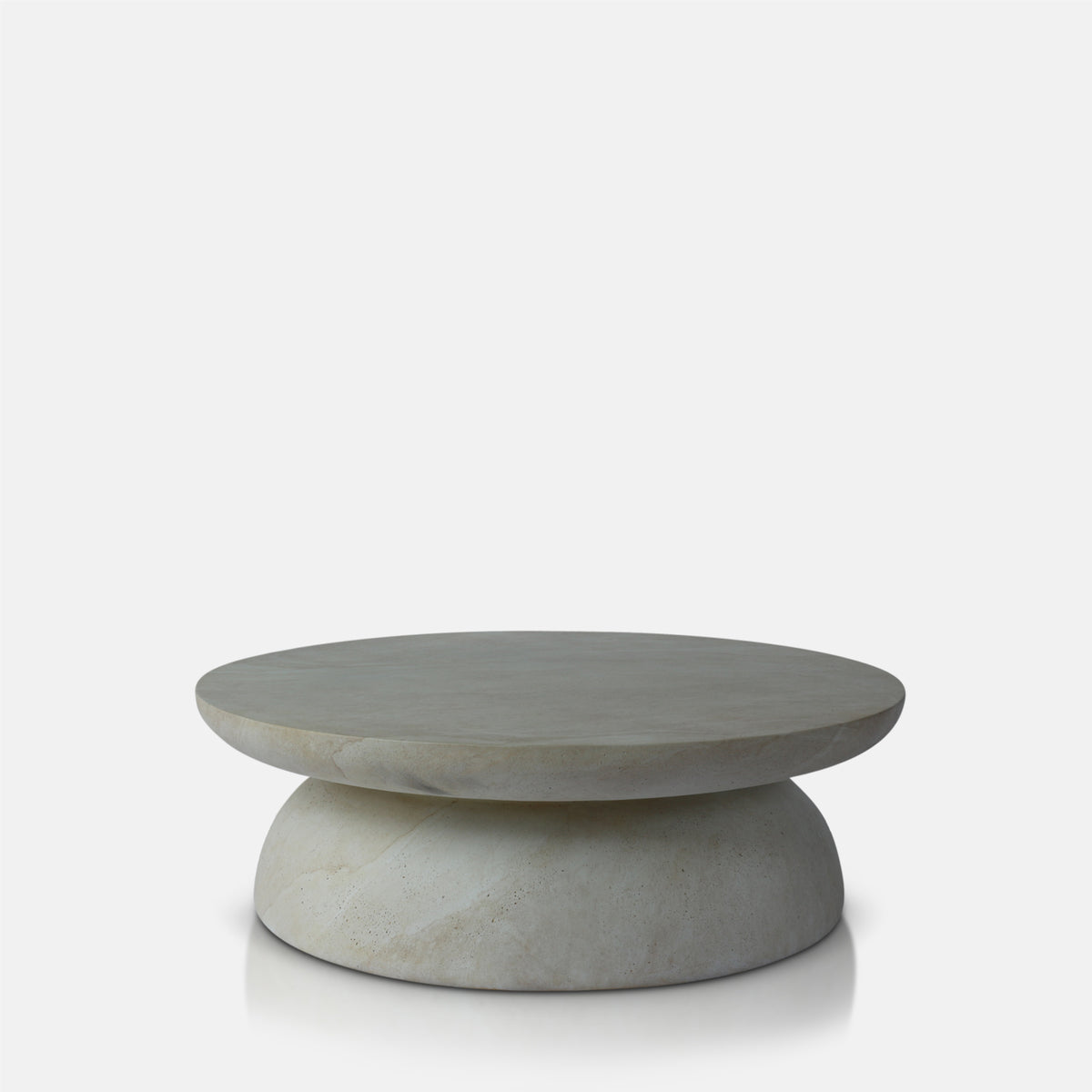 Round travertine effect coffee table with a soft beige finish, subtle cream and grey tones and a sculptural contemporary design. Diablo Round Coffee Table by Abigail Ahern, crafted from glass-reinforced concrete with a textured stone-inspired surface and suitable for both indoor and outdoor spaces. A luxury statement coffee table perfect for modern living rooms and stylish interiors, adding natural texture, timeless elegance and a refined focal point to your home decor.