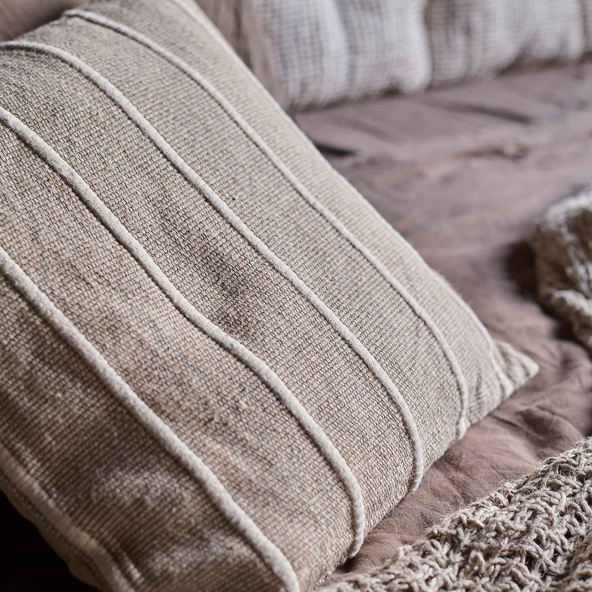 A closeup of the piping detail on the Edwina Striped Cushion.