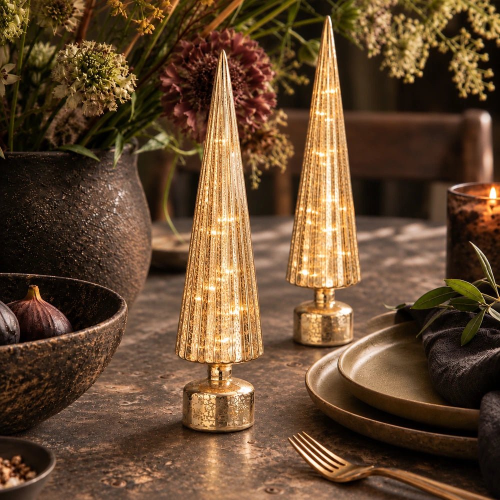 Elira Gold Tree Portable Lamps glowing on a dining table, styled beside a large floral arrangement, metallic tableware and warm ambient candlelight.
