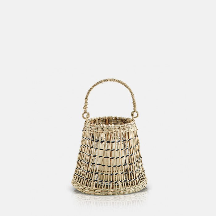 A cutout of the Etelle Seagrass Lantern, a small drum-shaped woven seagrass lantern with a handle.