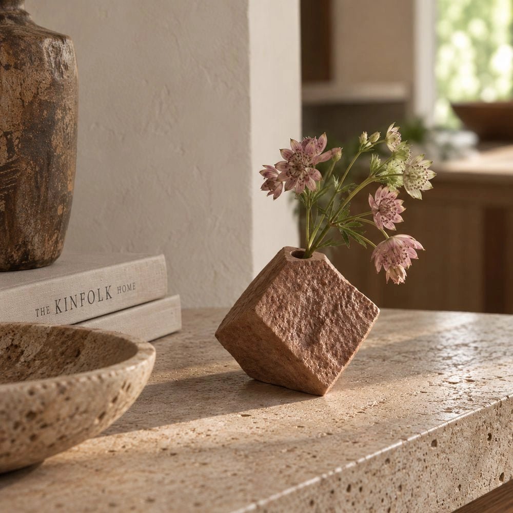Floyd Geometric Vase, Brick styled with delicate pink flowers on a pale stone counter, showing its angular shape and heavily textured surface.