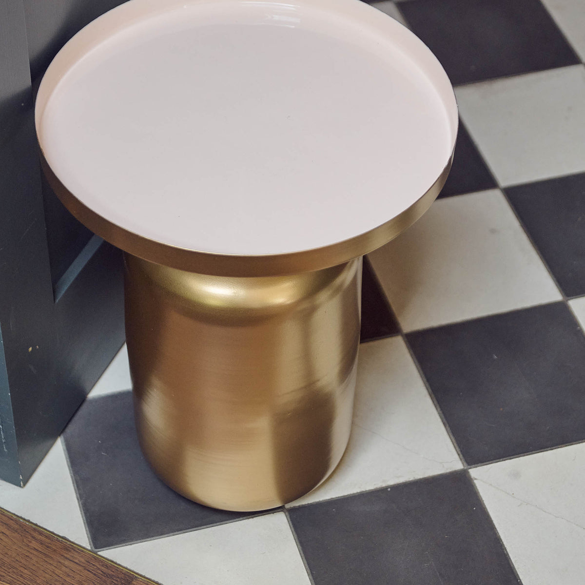A top view of the smooth white enamel circular top of the Giles Gold Side Table.