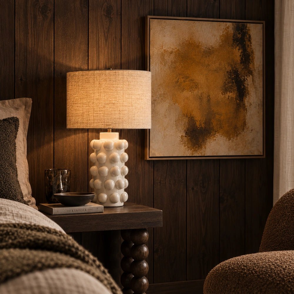 Greenock Bobble Table Lamp with rounded stacked base and neutral shade, shown in a close styled view with books and decorative objects in a warm interior.
