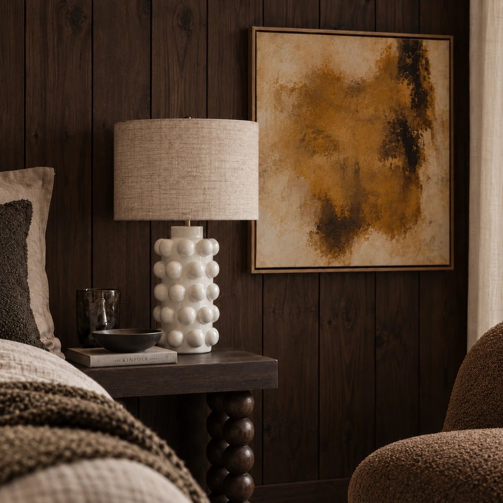 Greenock Bobble Table Lamp with sculptural rounded base and neutral shade, styled on a surface with books and decorative accessories in a softly lit room.