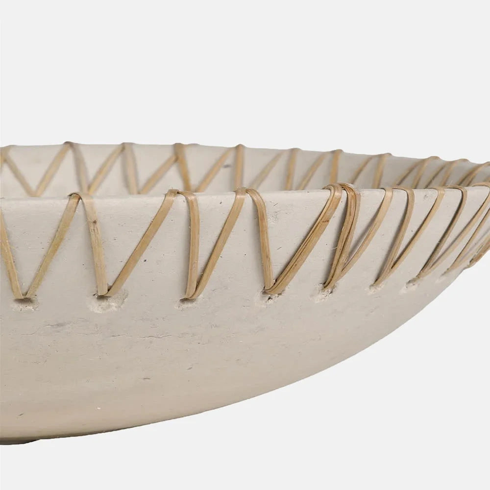 Halstead paper mache decorative bowl viewed close up from the side, showing its shallow curved body, off white finish and diagonal cord lacing around the rim.