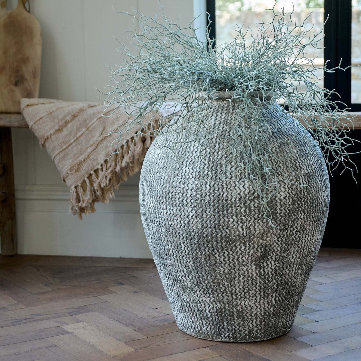Immi Terracotta Vase, an oversized vase featuring a design of horizontal zigzag lines in dark grey against light background.