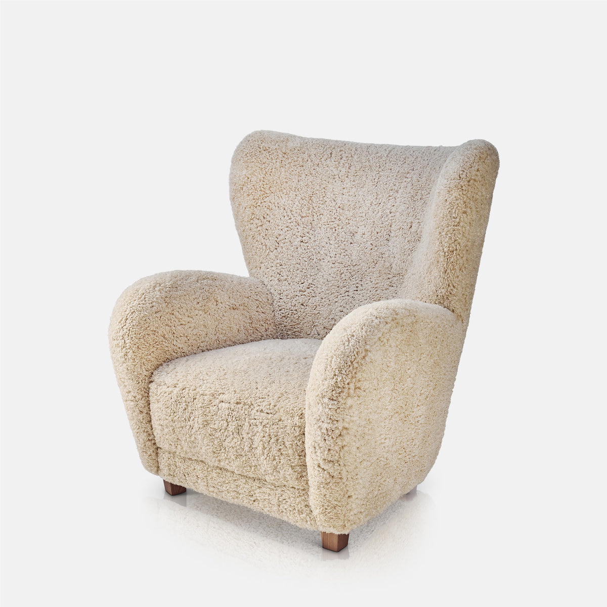 Cream faux fur armchair with an ultra soft textured finish, deep cushioned seat and inviting curved wingback silhouette. Karina Faux Fur Armchair by Abigail Ahern, designed as a statement accent chair that combines comfort with contemporary style. A luxury seating piece perfect for living rooms, bedrooms and cosy reading corners, adding warmth, texture and a stylish focal point to modern home interiors.