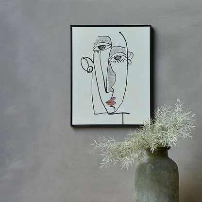 Picasso style face print in black and cream hung on a grey painted wall